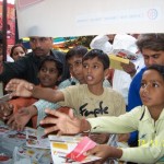 Children in Delhi reach for educational materials